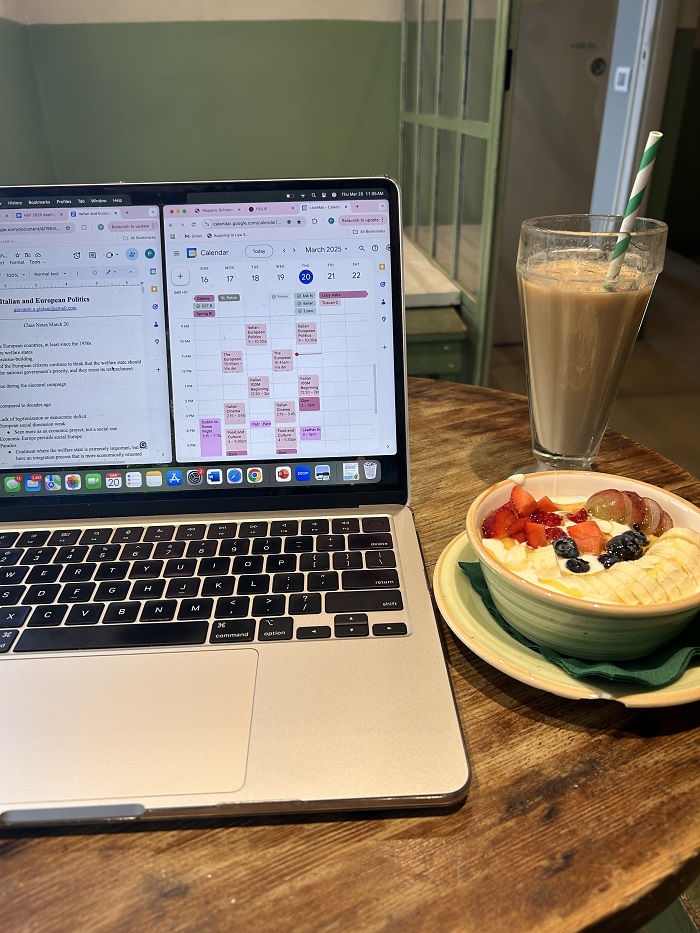 A smoothie and a greek yogurt besides a laptop with a student schedule