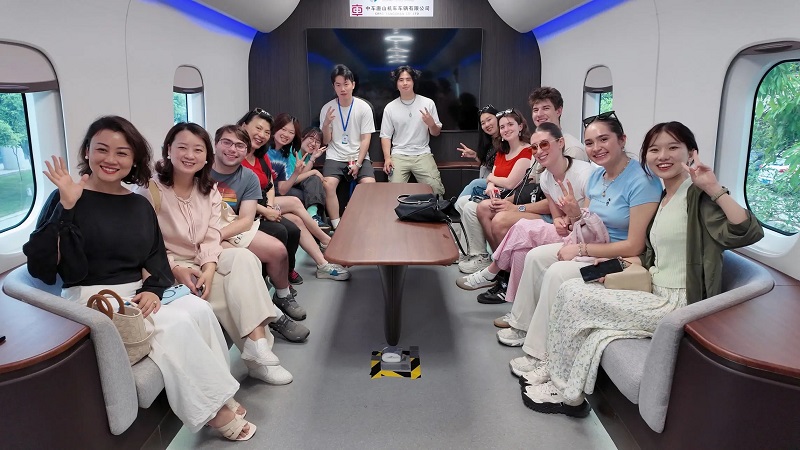 A group of CET Beijing students and staff sitting within a train at the maglev research center in Southwest Jiaotong University