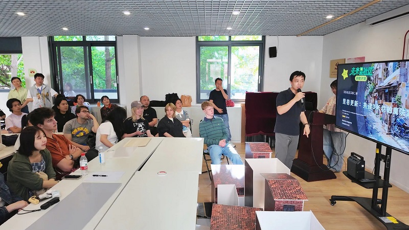 A group of CET Beijing students sitting in a classroom with a gust local speaker from the Yi Lin neighborhood