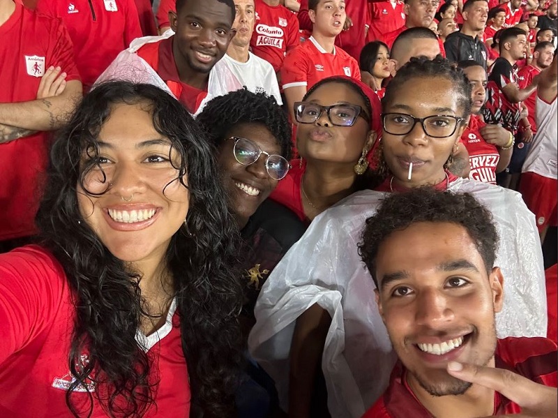 A group selfie of CET Colombia students in the midst of the crowd at an America de Cali game