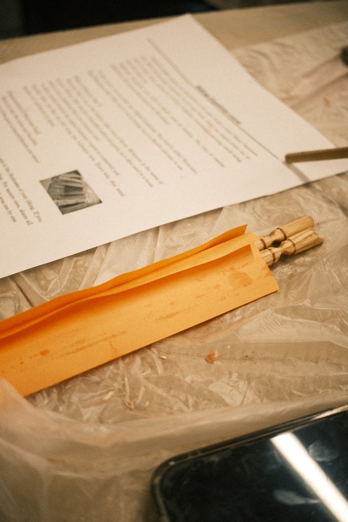 Close-up of chopsticks and a piece of paper with instructions laid on a table