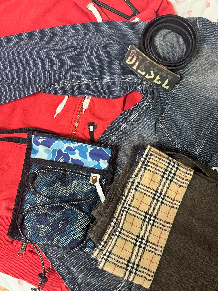 Burberry trousers, a Diesel belt and denim jacket, and an A Bathing Ape handbag laid out