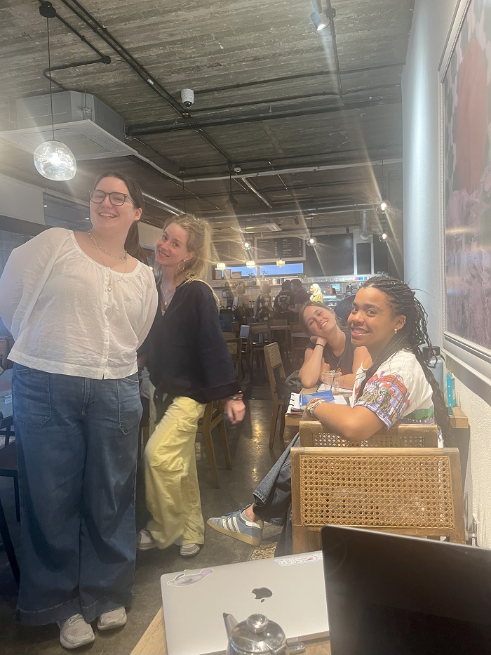 Four CET Jordan students smiling and posing while getting work done at Manara Café in Jordan