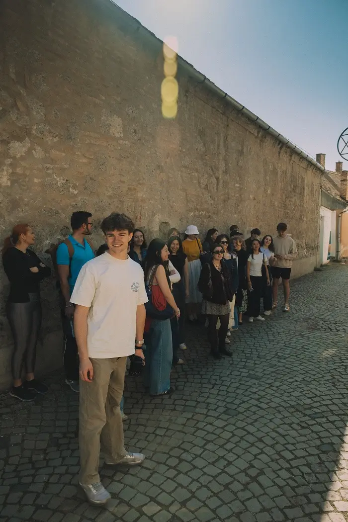 A group of CET Prague students standing along a wall in Budapest