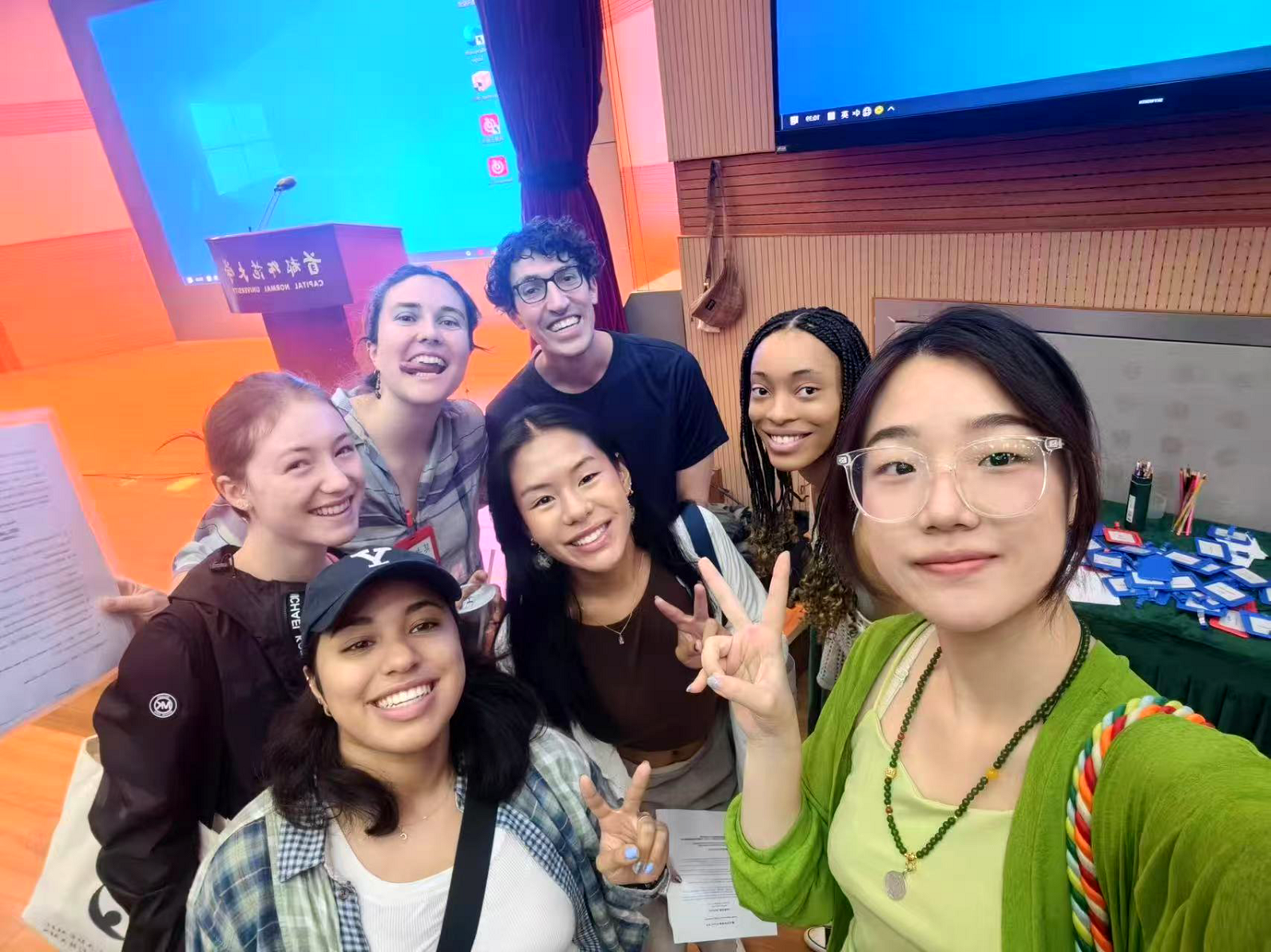 A group of CET Beijing staff and students smiling together while some hold up peace signs