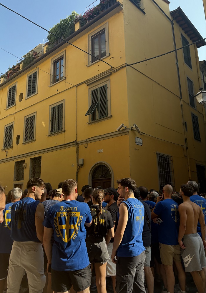 A large group of people standing by a building while wearing t-shirts for the Calcio Storico semi finals