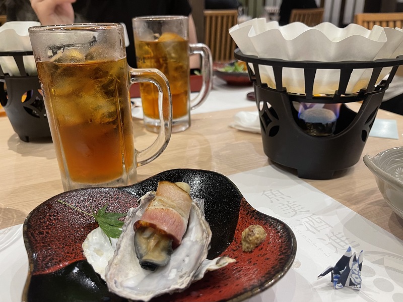 Glasses of drinks and a dish with Japanese food at a restaurant 