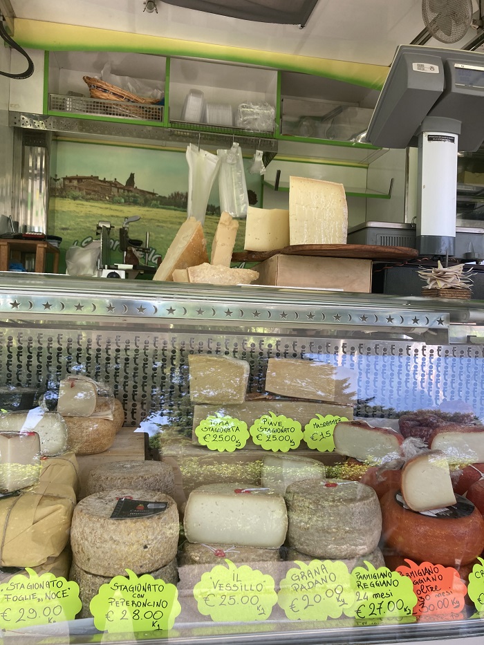 A large arrangement of cured meat and cheese stalls at a market called Fortezza Medicea