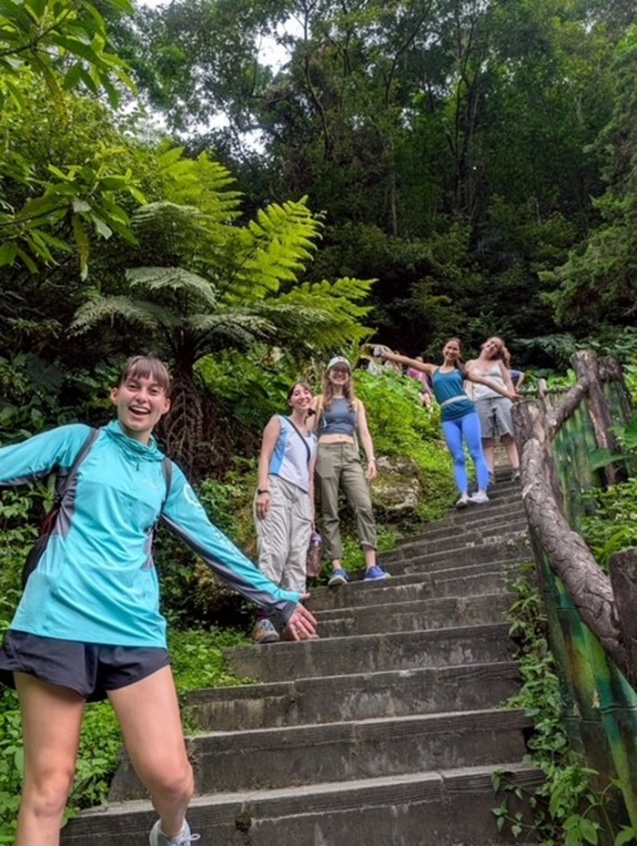 CET Taiwan students posing alongside stairs in a lush green space while on a hike