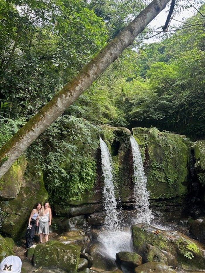 Two CET Taiwan students standing by a large waterfall