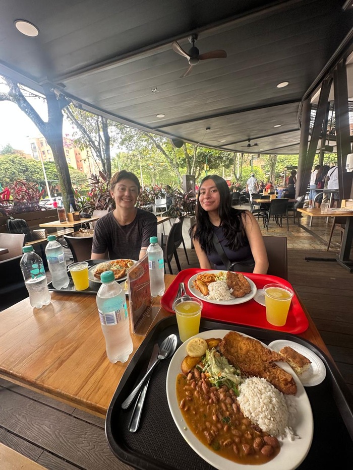 Trays of local Colombia meals with two females sitting across the table and smiling