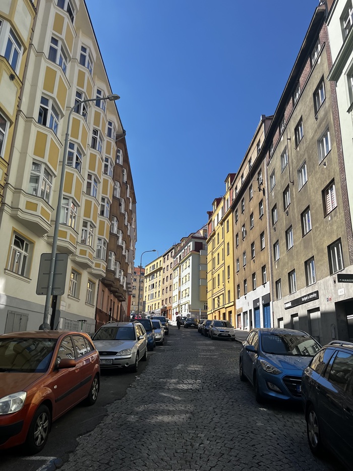 A view of cars along a street in Prague, Czech Republic with residential buildings on both sides