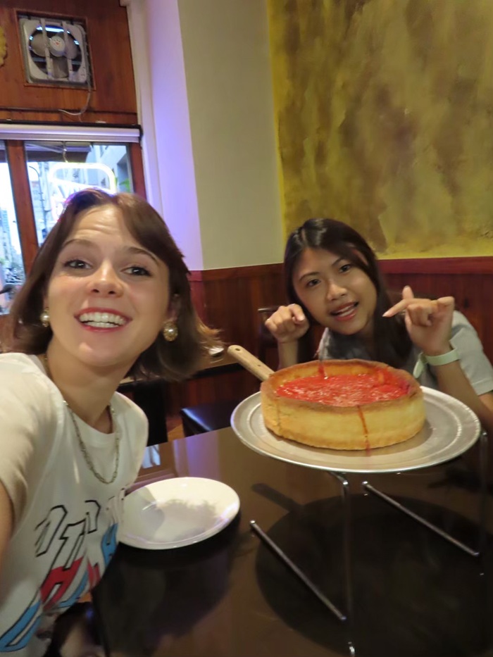 A CET Taiwan local roommate and a study abroad student smiling and posing by a Chicago deep dish pizza
