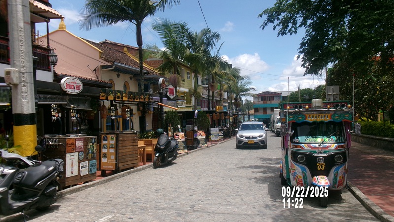 A street in Guatapé of shops and cars in the middle of the road