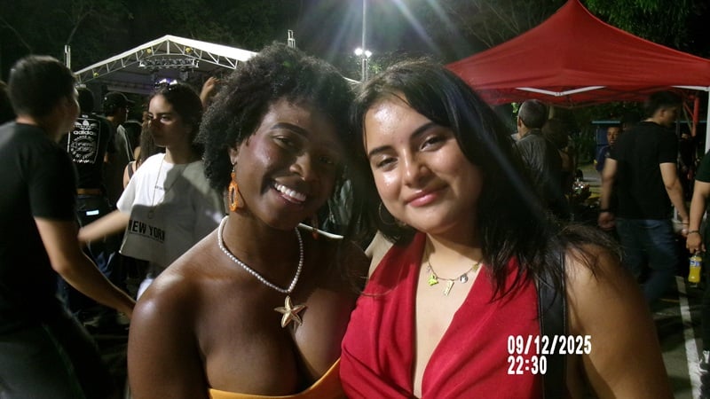 Two CET Colombia students smiling while at a university event during the night