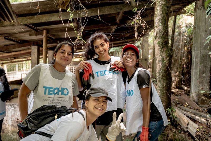 CET Colombia students volunteering and smiling while wearing shirts that say "Techo" on it
