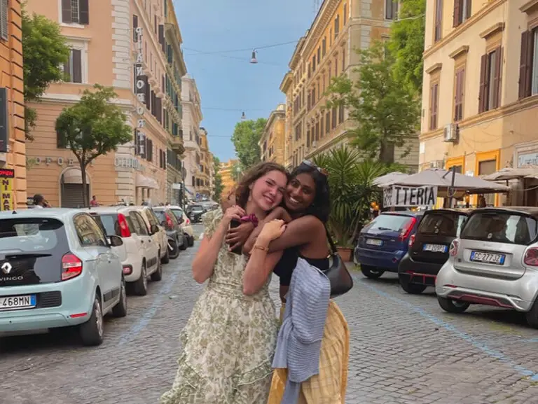 students hugging in street