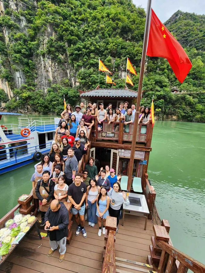A large group of students, staff, and others while on a boat tour along the Huajing river