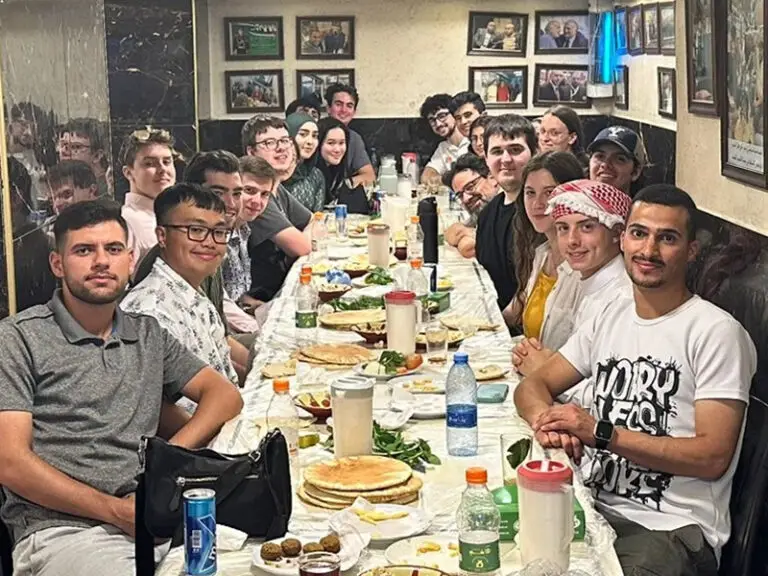 students and staff at dinner table