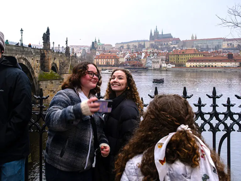 students taking selfie in front of Chrales bridge