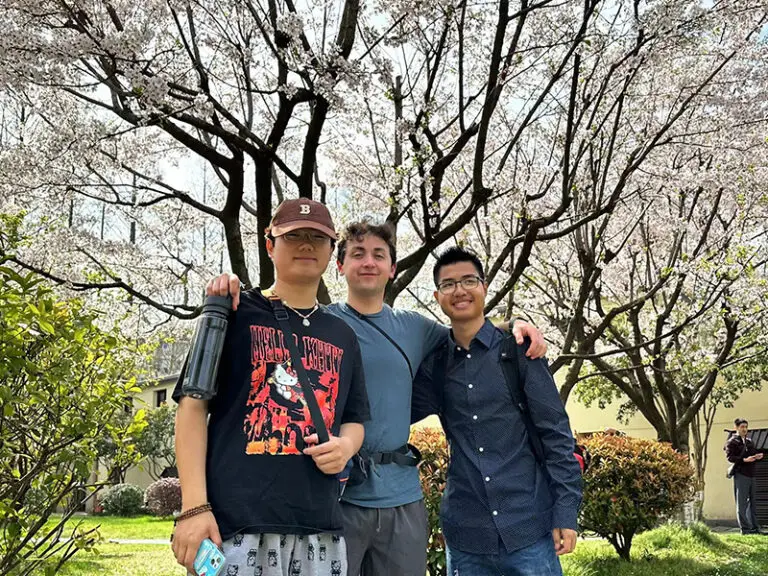 students smiling under cherry blossom trees
