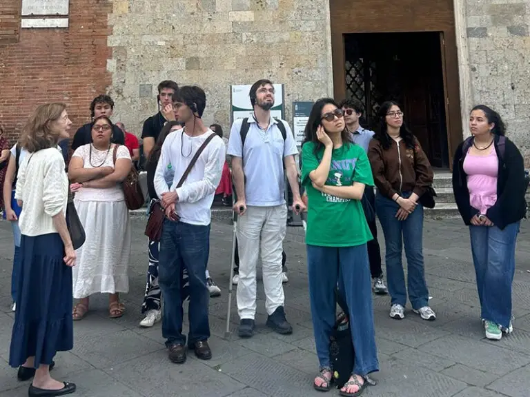 students listening to tour guide on street