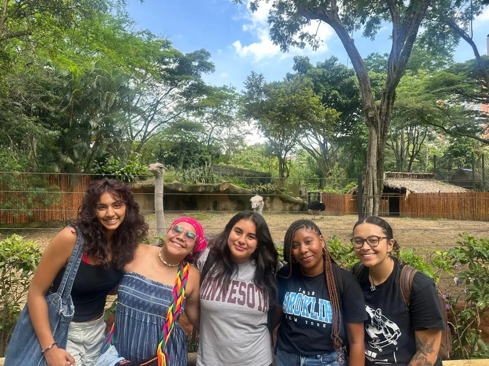 A group of five CET Colombia students posing by ostriches at the zoo in Cali