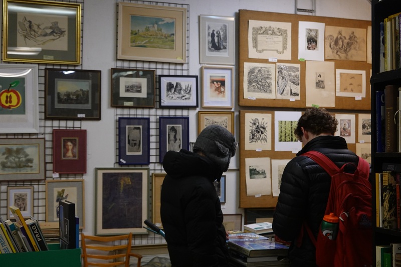 People browsing through posters in a poster store in Prague