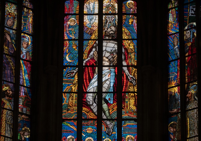 Stained glass window of Jesus being held by a priest at Saint Vitus’ Cathedral in Prague