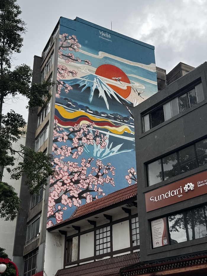 A mural of Mount Fuji, a large sun, and cherry blossoms in São Paulo, Brazil