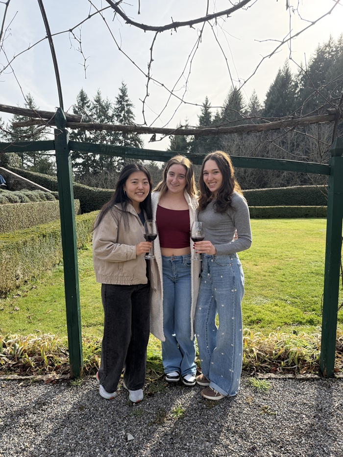 CET Florence students holding glasses of red wine while standing outside at a wine vineyard