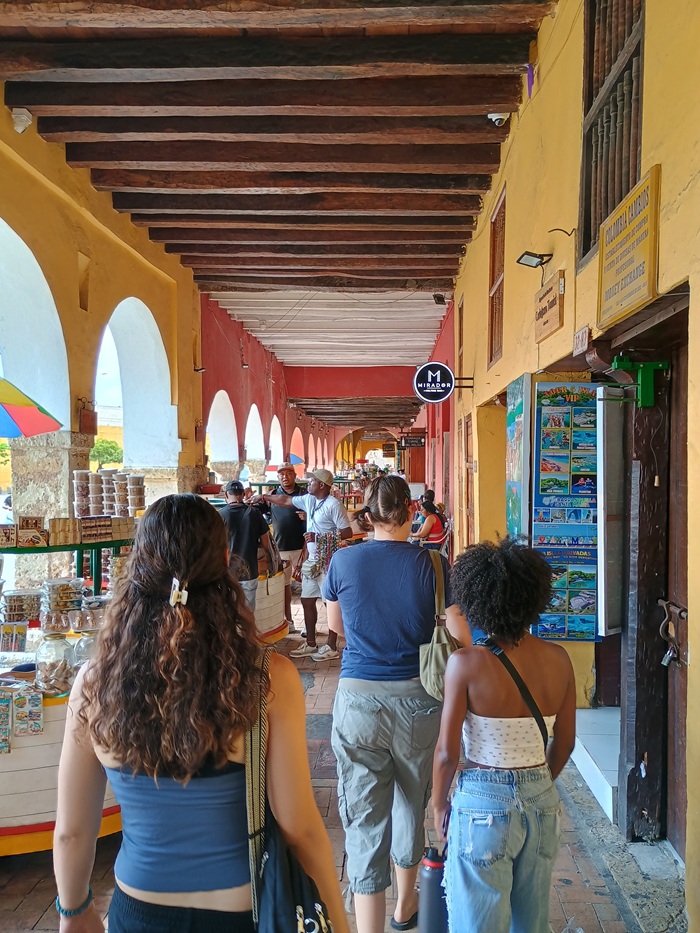 People walking along shops in La Plaza de los Coches in Cartagena