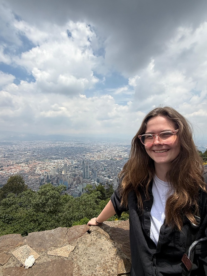 A CET Colombia smiling while at the top of Monserrate with panoramic views