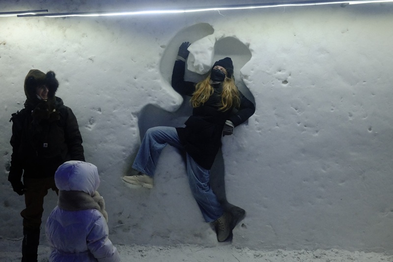 A CET Beijing student posing within a cutout in ice at the Harbin Ice and Snow World in Harbin, China 