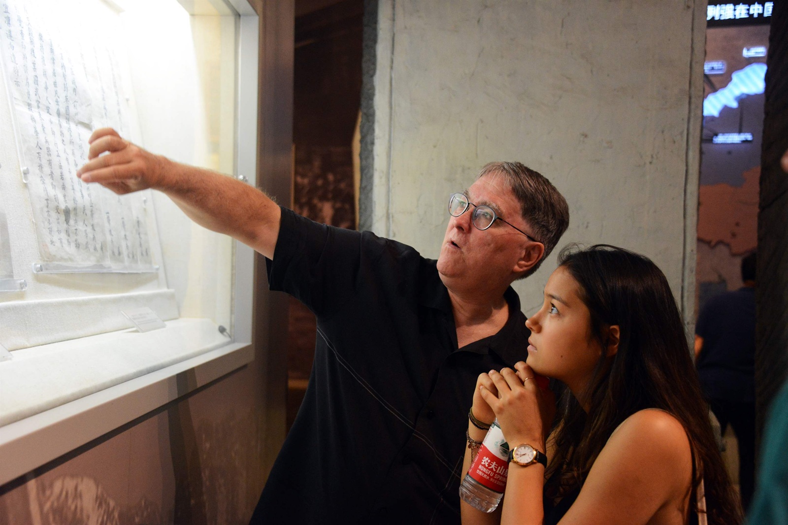 Two individuals observing an exhibit in a museum in Beijing, China