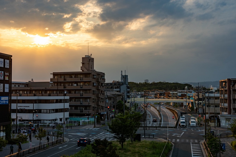 A metropolitan cityscape in Japan, featuring a highway at sunset.