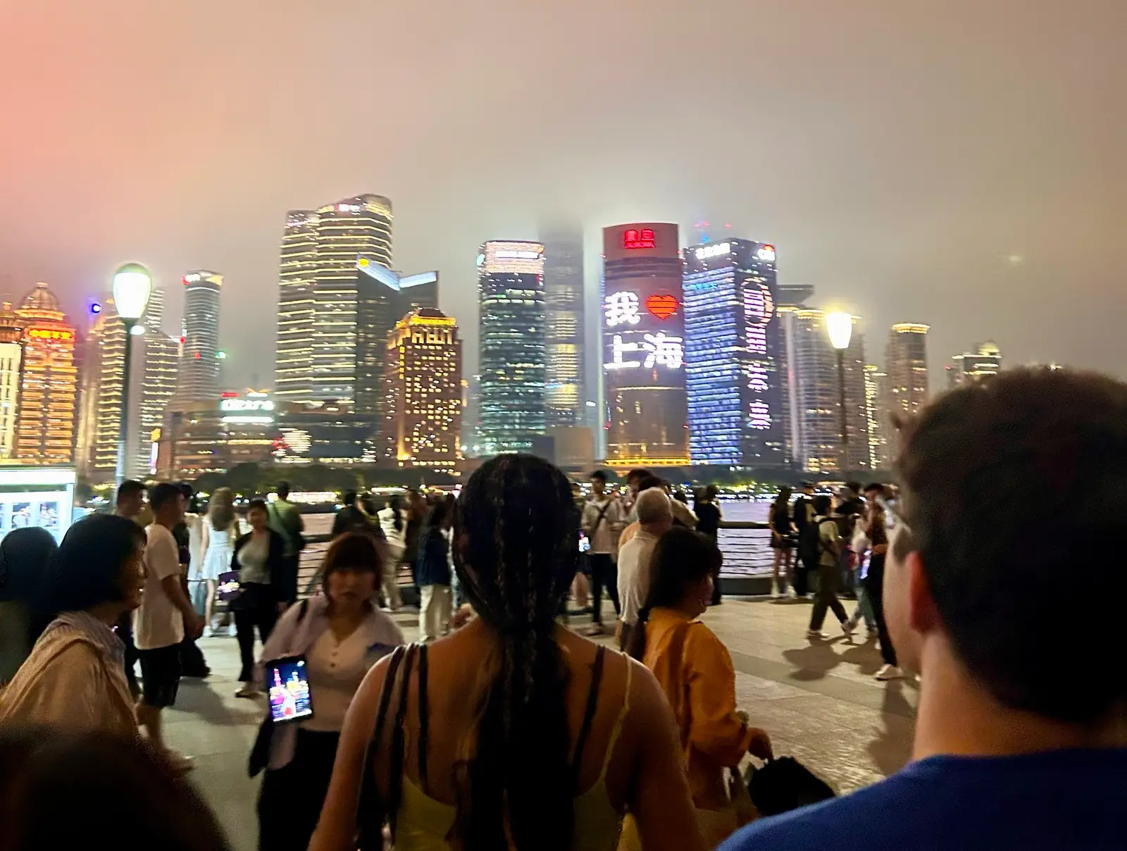 The illuminated skyscrapers of the Pudong skyline in Shanghai, specifically the Shanghai Tower and Jin Mao Tower, often featuring the message "I ❤️ Shanghai."