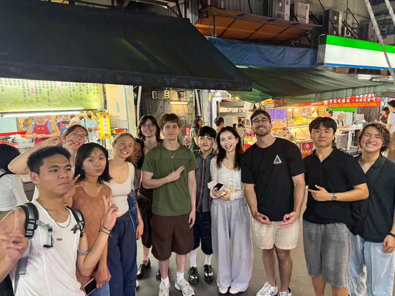 A group of CET Taiwan students and local roommates enjoying the vibrant atmosphere of a night market in Taiwan.