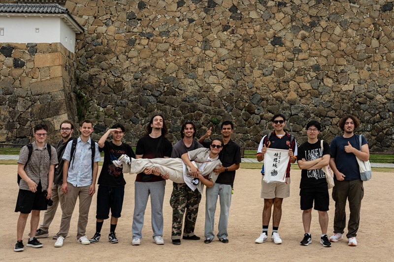 A group of CET Japan students standing and posing by the base of the Himeji Castle in Osaka, Japan.