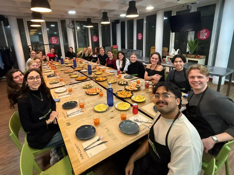 group of students looking at camera sitting at dinner table covered in food