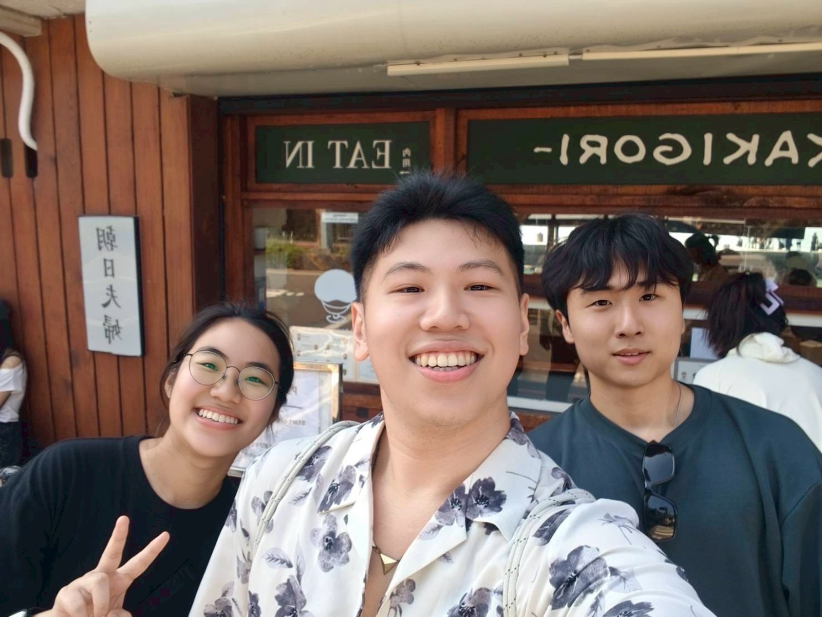 Three people within the CET Taiwan program smiling while standing outside of a food place