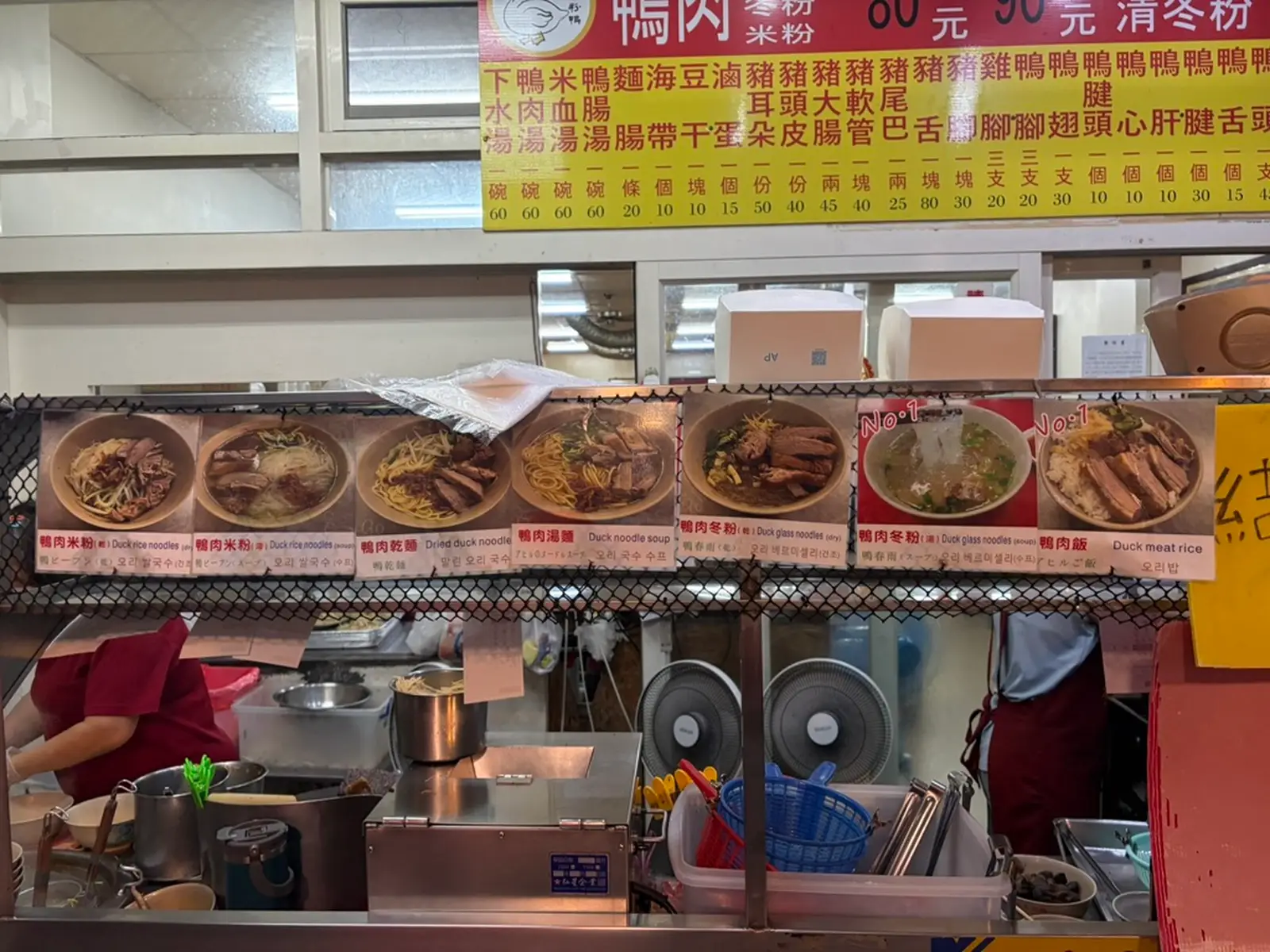 The front of a street-food restaurant displays photos of food items, each labeled with Chinese characters