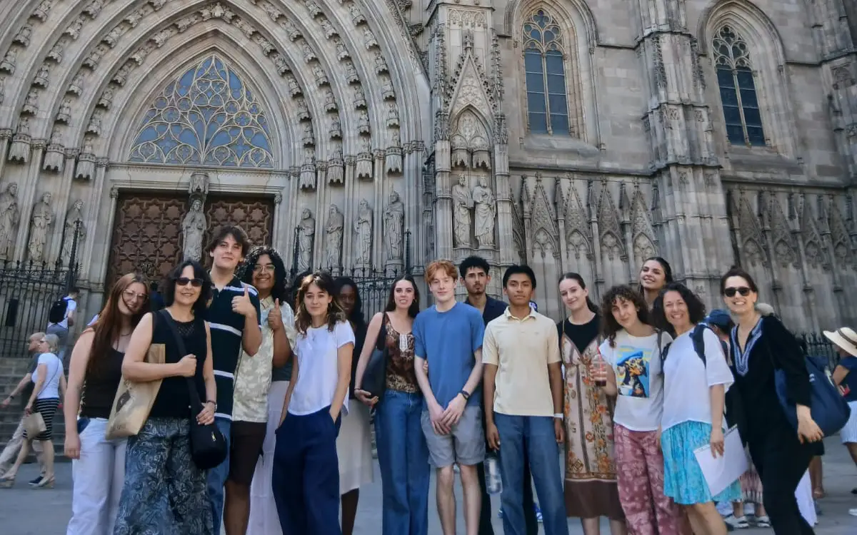 students smiling at camera with view of city in the background