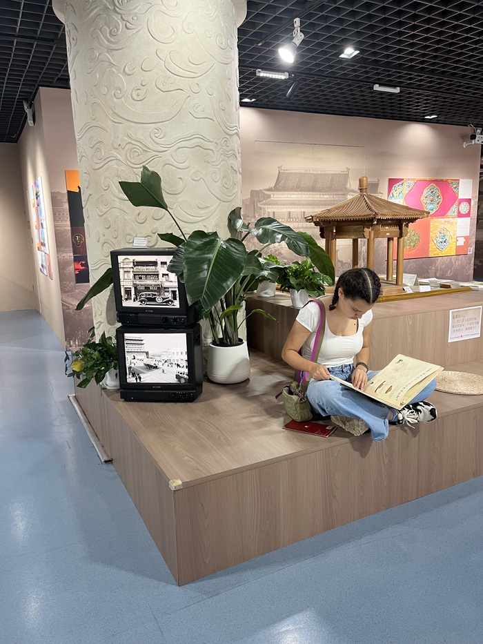 A CET Beijing student flipping through a collection of stories at the Beijing Planning Exhibition Hall.
