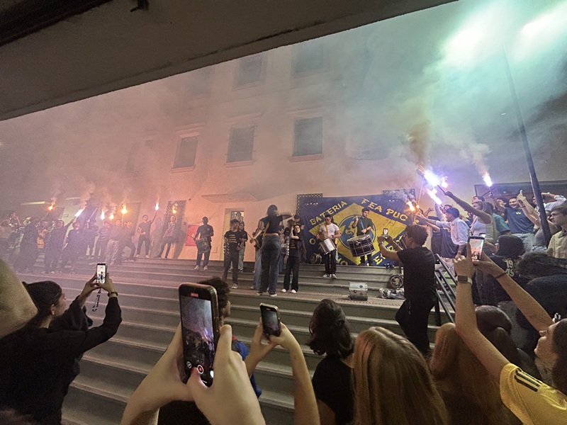 Students performing outside on the Pontifícia Universidade Católica de São Paulo campus at night