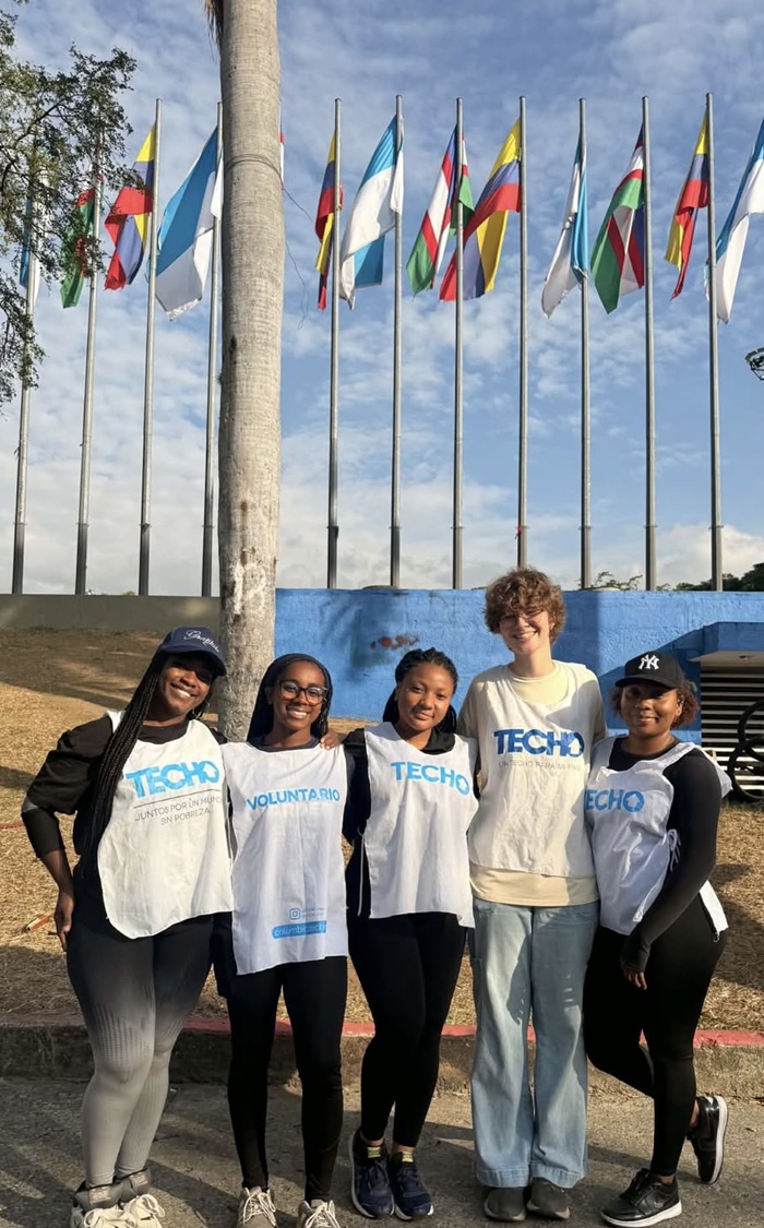 Five volunteers posing together in TECHO shirts.