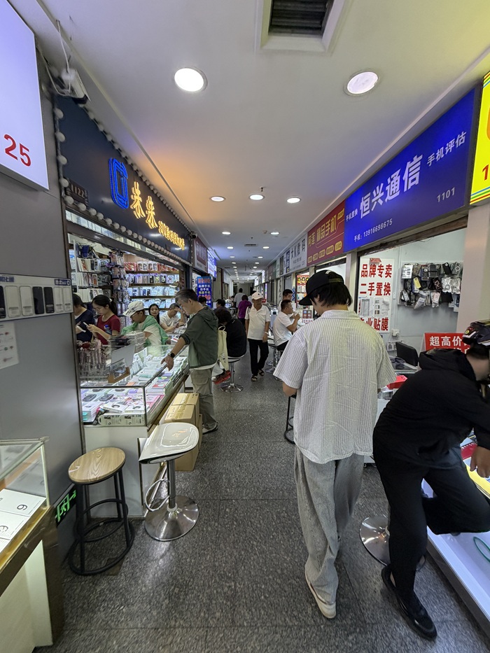 Shoppers browsing stalls in an indoor phone market
