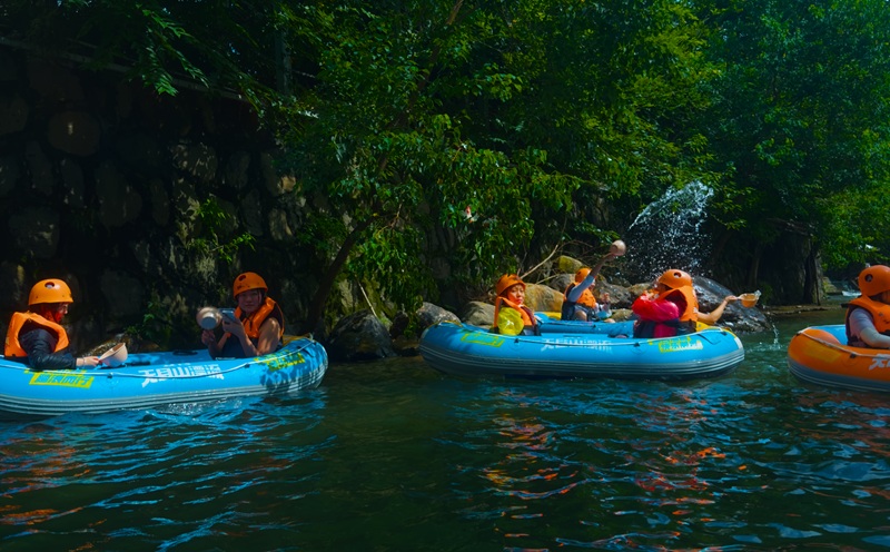 People rafting along a tree-lined river