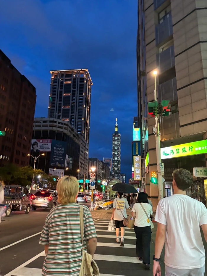 CET Taiwan students crossing a crosswalk at dusk in a street in Taipei