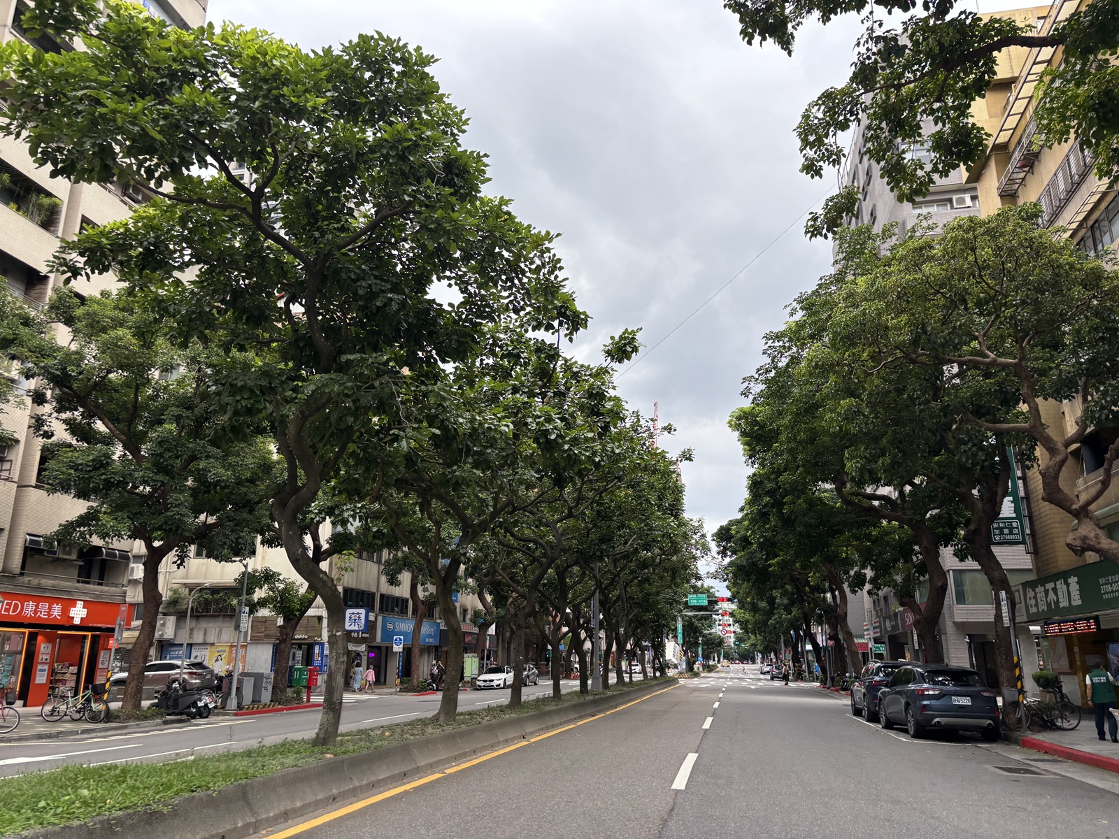 A green, tree-lined street scene in Taipei, Taiwan, specifically around the Minsheng Community and Fujin Street area.
